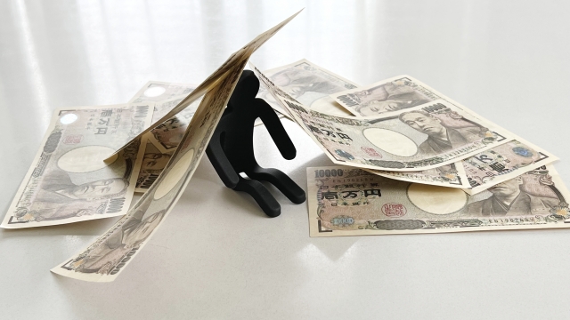お金の上でうなだれる。市原市で借金返済の相談は無料でできます
