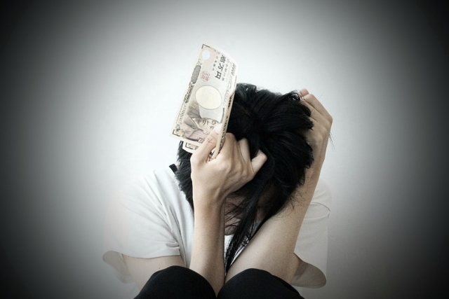 お金を手に頭を抱える。栃木市で債務整理の無料相談が弁護士にできます